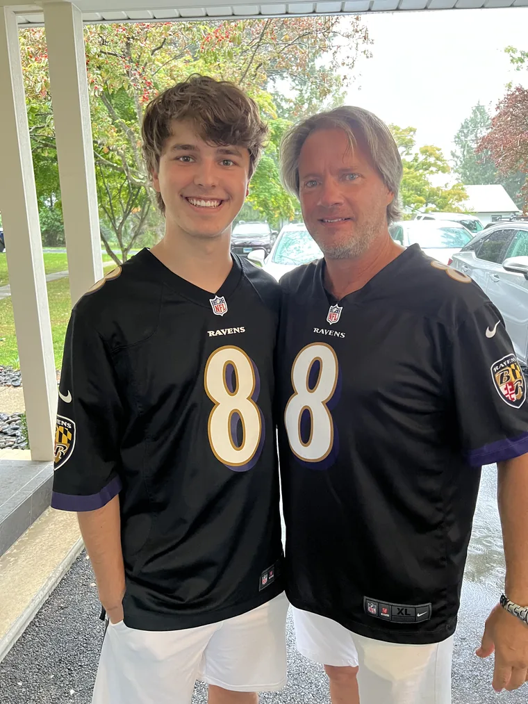 Brock Pivec in a Ravens jersey with his dad at the family bar