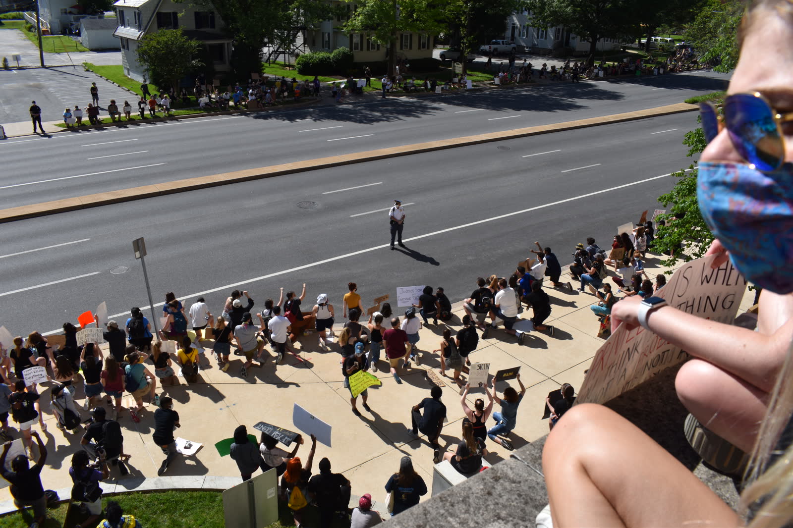 Aerial view of a 2020 protest, demonstrators kneeling in the street